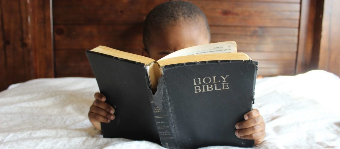 photo-of-child-reading-holy-bible-935944